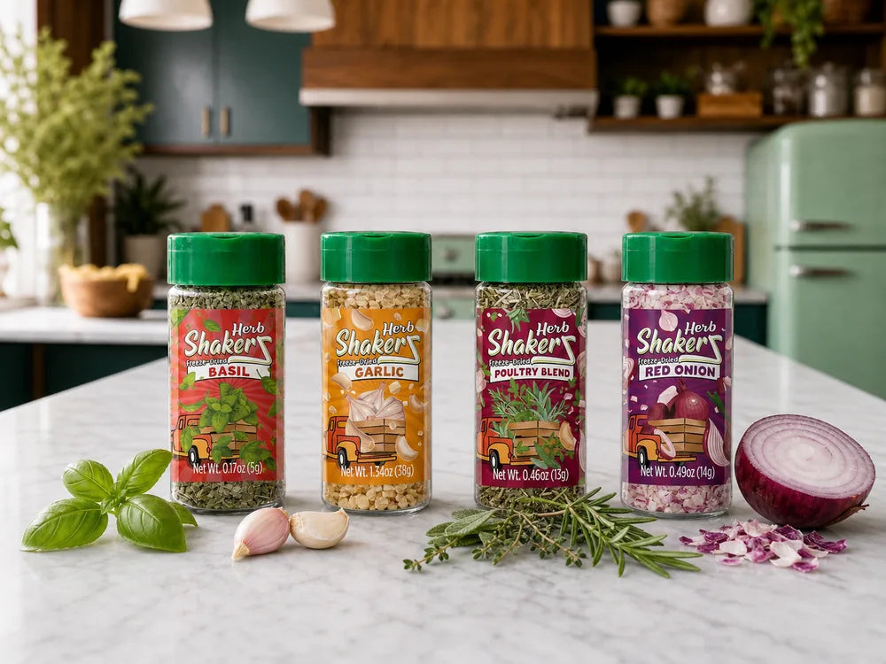 Four Herb ShakerZ bottles — Basil, Garlic, Poultry Blend, and Red Onion — on a kitchen counter with fresh herbs